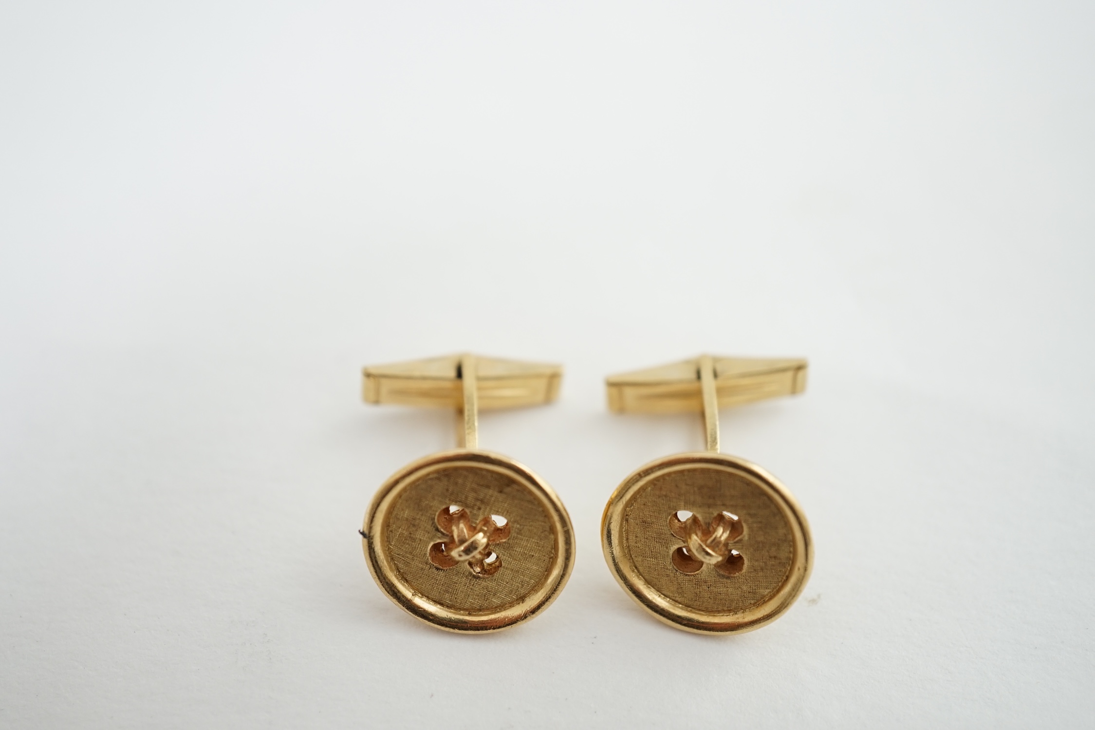 A pair of 14K yellow gold button design cufflinks, by Merrin & Co